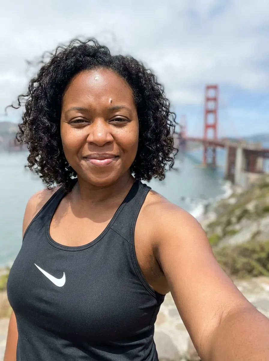 Original selfie input — woman in a black athletic tank top outdoors